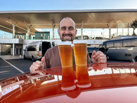UGC happy man smiling with beers in parking lot