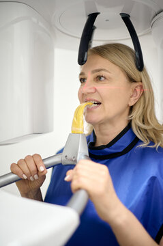Middle age woman doing teeth roentgen at light medical clinic