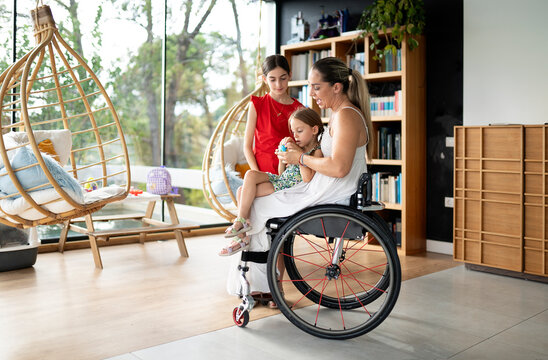 Mother playing with daughters in modern home