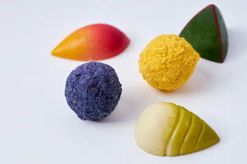 Assorted gourmet chocolate truffles and pralines in vibrant colors on a white background, luxury confectionery  
