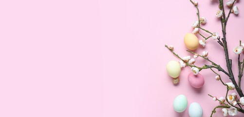 Easter eggs and blooming spring branches on pink background with space for text, top view