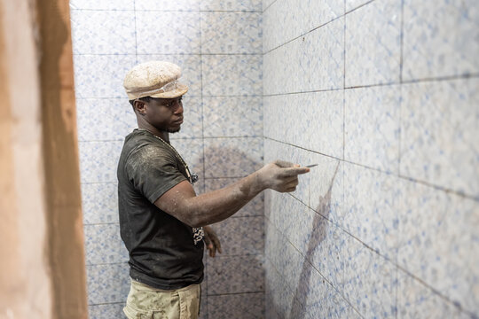Bricklayer working on bathroom tiles in Senegal