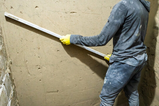 Bricklayer smoothing concrete on wall with large trowel in Senegal