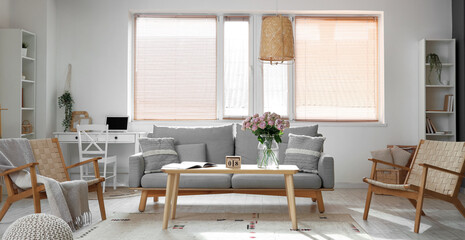 Interior of living room with sofa and roses in vase. International Women's Day