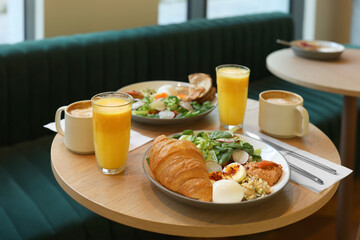 Tasty breakfast. Different meals and drinks served on wooden table in cafe