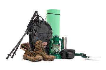 Set of camping equipment with backpack, trekking poles and boots on white background