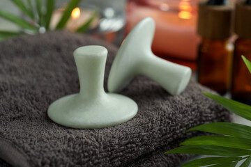 Spa stones, towel and green leaf on table, closeup