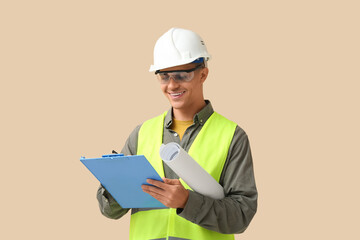 Young male engineer with clipboard and blueprint on beige background