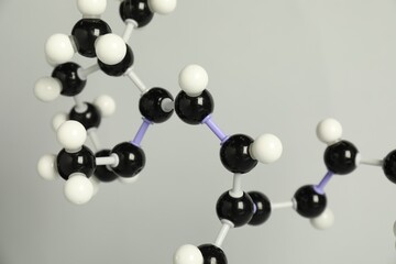 Molecule of retinol (vitamin A) on light grey background, closeup. Chemical model