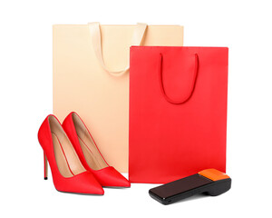 Payment terminal, shopping bags and heels isolated on white