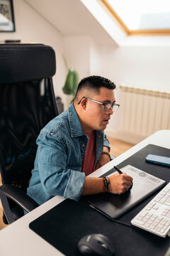 Man with Down syndrome working with digital tablet at desk