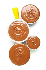 Bowls of tasty melted chocolate on white background