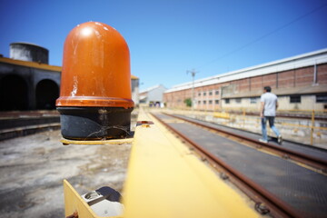 Yellow rotating indicator light for moving machines on the left side.