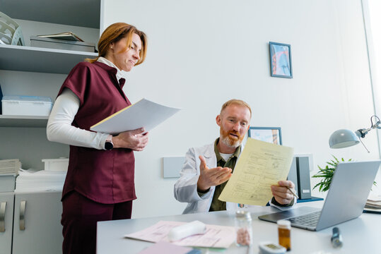 The doctor and the nurse are studying the documents