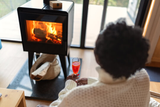 Woman looking at fire while drinking cocktail
