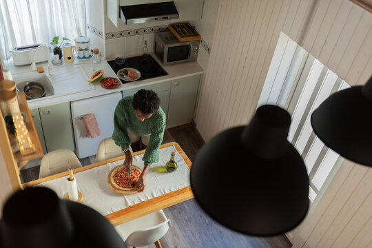 Woman cutting pizza into slices