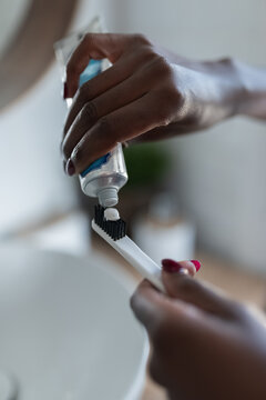 Woman putting toothpaste on toothbrush