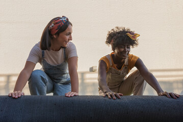 Happy women unrolling artificial turf