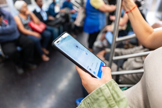 Tourist using smartphone gps app on New York City subway train