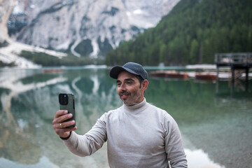 man taking a selfie at braies lake in dolomites