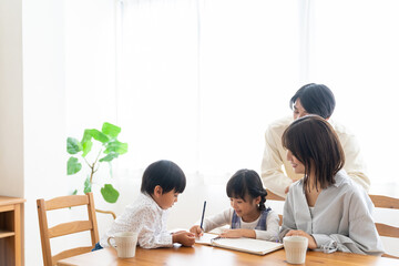 勉強する女の子と見守る家族