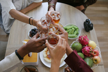 Obraz premium Top View of Muslim People Clinking Glass of Tea To Break Fast During Ramadan Feasting Month at Home