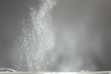 Wallpaper Background of silver diamond glitter powder sand creating abstract bokeh festive sparkle. Bokeh particle element of silver diamond glitter sand light up luxury balance background