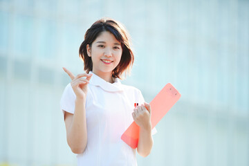 人差し指を立てる白衣の女性