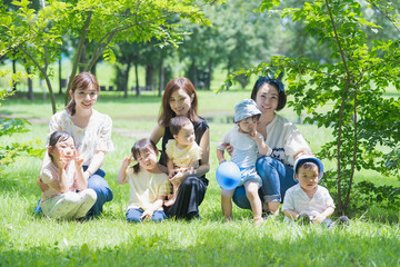 Fototapeta premium 緑あふれる公園で遊ぶ家族たちの集合写真