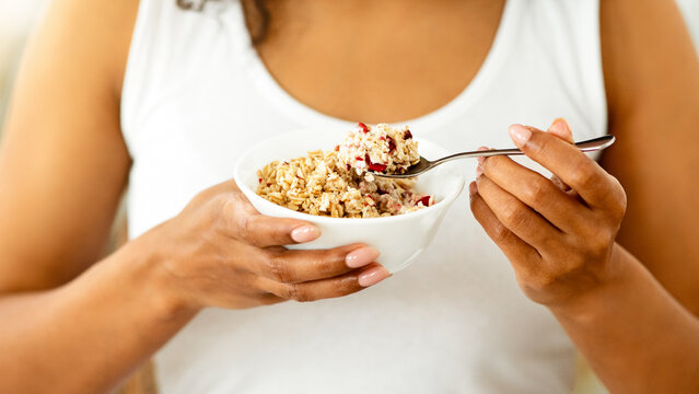 Healthy Diet. Unrecognizable African Woman Eating Oatmeal With Fruits For Breakfast, Cropped Imgae, Closeup