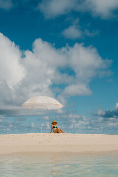 Relaxation on a sunny beach with a parasol and clear blue skies