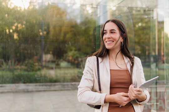 Portrait of a young businesswoman with a park in the background.