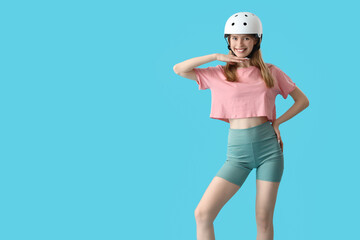 Beautiful young woman in helmet on blue background