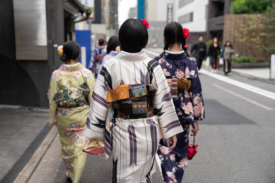 Anonymous women wearing kimono walking on the street