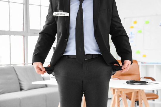 Bankrupt businessman with empty pockets in office, closeup