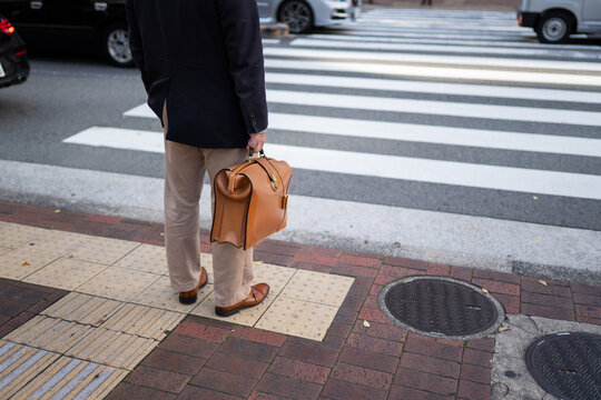 Anonymous businessman at pedestrian crossing 