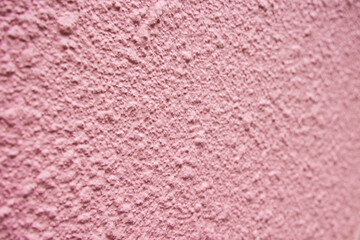 Pink mortar exterior wall of apartment. The texture of the pockmarked wall.