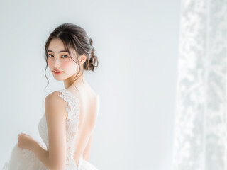 背中が美しいウエディングドレスを着た若い花嫁が振り返る