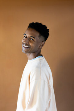 Studio portrait of young cheerful man smiling at camera