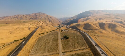 Aerial view of Interstate 5 highway traffic moving through the arid landscape of Grapevine,...