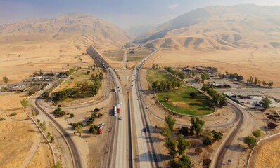 Aerial view of Interstate 5 highway running through Grapevine, California farmland. Cars and trucks...