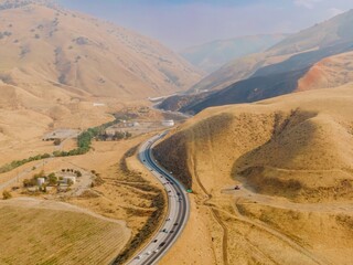 Aerial view of Interstate 5 highway running through Grapevine, California farmland. Cars and trucks...