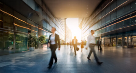 Obraz premium People walk in a modern, bright, spacious office area with contemporary architecture. Daylight illuminates the professional business environment.