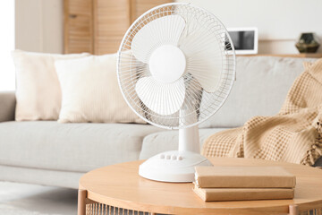 Interior of light living room with modern electric fan on coffee table, closeup