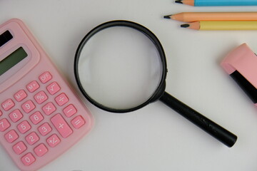flat lay of a blank note book for text space. Educational and financial concept with text space on white background. surrounded by tools such as pen, alarm clock and calculator