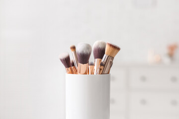 Holder with makeup brushes at home, closeup
