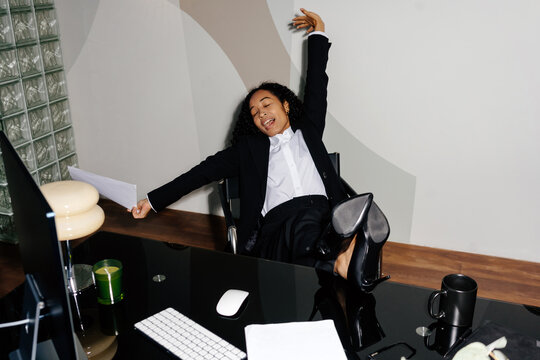 Businesswoman stretching and yawning at desk