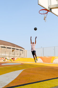 Boy  jumping and throwing the ball to the basket