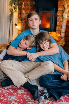 Siblings enjoy cozy time together by the fireplace