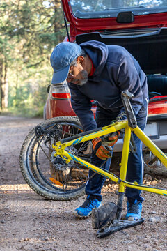 A mature adult man prepares his bicycle chain for mountain biking